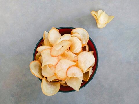 Cassava chips served in a bowl. Traditional snack made from thinly sliced ​​cassava and then fried. snacks to accompany your time relaxing or watching TV shows. Keripik singkong. Top view