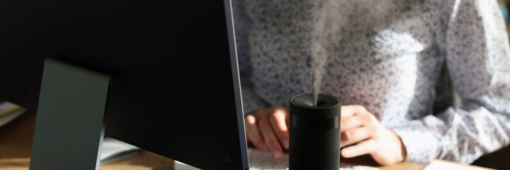 Woman types on keyboard while diffuser spreading aroma