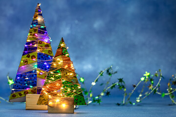 festive decorated christmas trees with glowing holiday garlands lights.