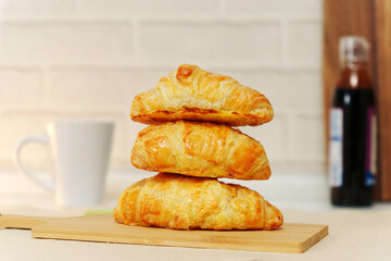 Croissant with his hand in close-up on the table. Breakfast. Selective focus