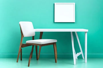 Zelfklevend Fotobehang A minimalist white chair and table against a vibrant turquoise wall with a blank white frame. © Love Allah