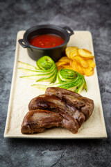 beef meat with chips, cucumbers and barbecue sauce, side view