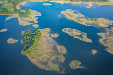 Aerial view of nature of National Park Braslav Lakes on sunny day. Large and small islands on Lake Snudy covered woods or reeds.
