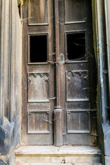 Rusted metal doorway into ancient crypt in old European graveyard.