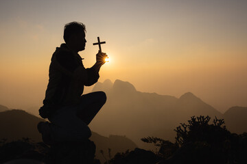 Silhouette of christian prayers raising hand while praying to the Jesus spirituality and...