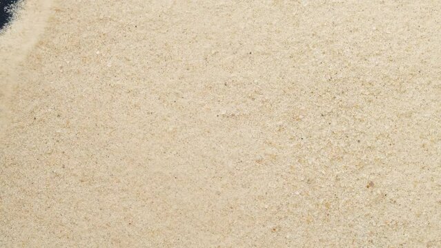 Closeup of sand transition blowing over black abstract background in slow motion