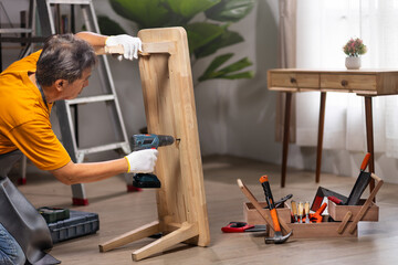 Worker repair wooden drawer of cabinet in living room.