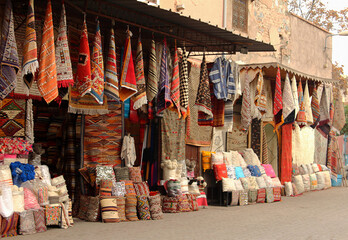 Traditional textile shop with colorful carpets and cushions  displayed on the street in Marrakech, Morocco.