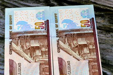 Reverse sides of 50 LE fifty Egyptian pounds banknote series 2001 features an image of temple of Edfu, winged scarab and a pharaonic boat, selective focus of Egyptian money bill, old vintage retro - obrazy, fototapety, plakaty