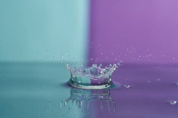 Group of colorful water droplets fall and bounce on a water surface