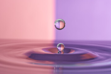 Group of colorful water droplets fall and bounce on a water surface