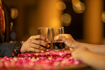 Close-up view of a two glasses of beer in hands. Beer glasses clinking at bar or pub.
