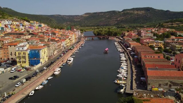 Flyover aerial drone flying above river Temo in touristic town of Bosa, Sardinia