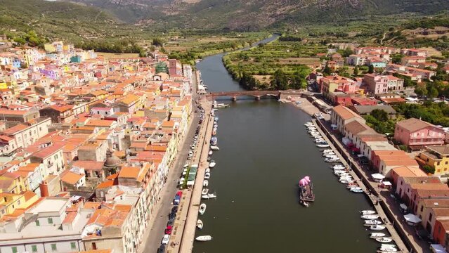 Flyover aerial shot of river Temo in picturesque town of Bosa, Sardinia, summer
