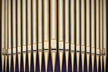 Naklejka premium Row of gold colored organ pipes
