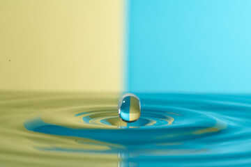 Group of colorful water droplets fall and bounce on a water surface