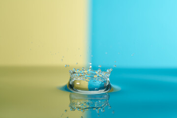 Group of colorful water droplets fall and bounce on a water surface