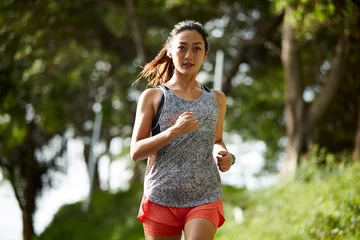 Poster young asian woman jogging running outdoors in park © imtmphoto