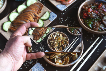 Guest taking a photo of food on mobile phone.
