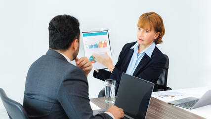 Business woman showing document to business man, professionals discussing papers working in office at meeting.