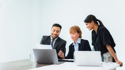 Three smiling diverse business colleagues having business strategy meeting.