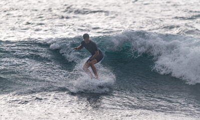Young man riding a wave in the sea