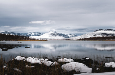 winter landscape with snow covered mountains and lake in North Finland