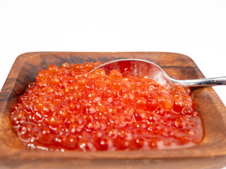 Wooden cup with red caviar on a white background. Red caviar close-up.