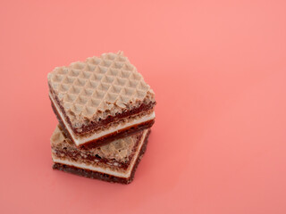 Delicious chocolate wafers with hazelnuts on a pink background. Wafers with chocolate and nuts.