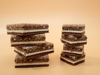 Delicious chocolate waffles with hazelnuts on an orange background. Wafers with chocolate and nuts.