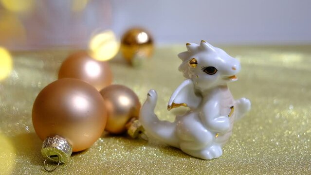Chinese New Year, decorations with cute figurine baby dragon on golden background. Glowing blurred flares light. Atmospheric mood