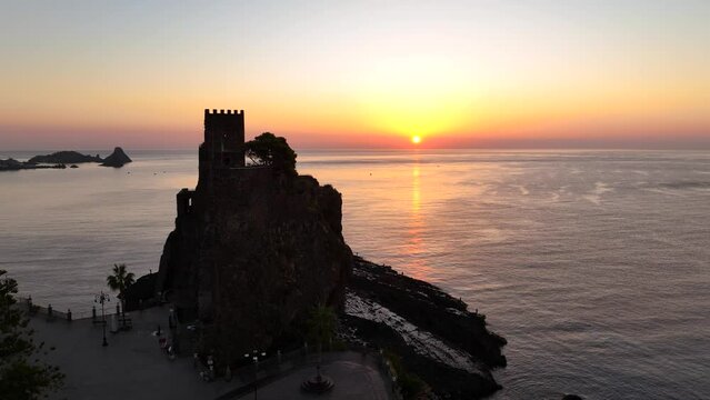 Il borgo marinaro di Aci Castello, Sicilia, Italia.
Vista aerea all'alba del castello sulla roccia vulcanica a picco sul mare.
