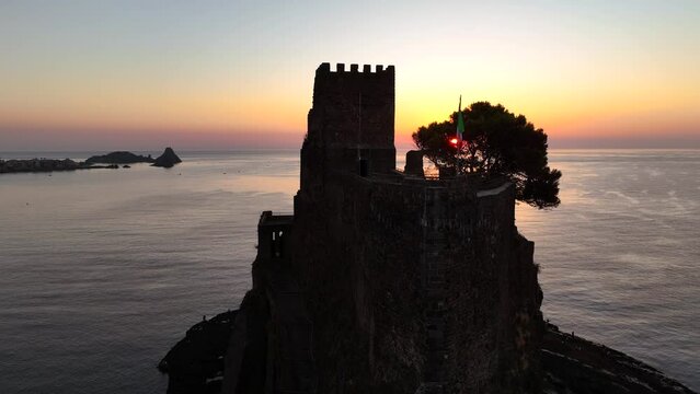 Aci Castello e sullo sfondo le isole Ciclopi di Acitrezza. Sicilia, Italia, 
Vista aerea all'alba della costa vulcanica siciliana tra Aci Castello e Acitrezza.