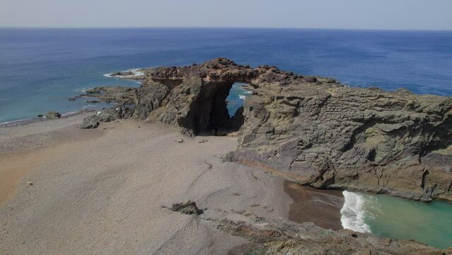 Fuerteventura Island: aerial view traveling out to the Jurado arch and the beach on a sunny day with beautiful colors.