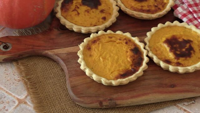 plusieurs tartelettes au potiron sur une planche &agrave; d&eacute;couper	