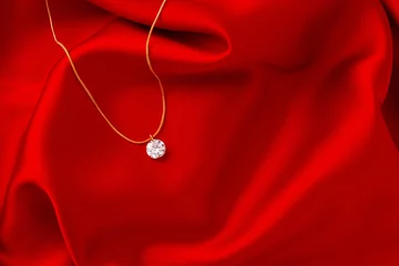 Poster Golden necklace with pendant on red silk background © fotofabrika