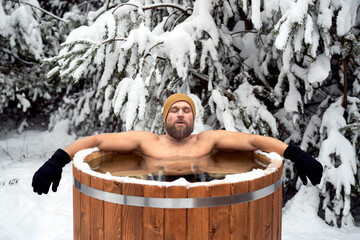 Caucasian man take the winter bath in tube outdoors in forest