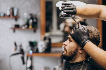 Client doing hair cut at a barber shop salon - obrazy, fototapety, plakaty