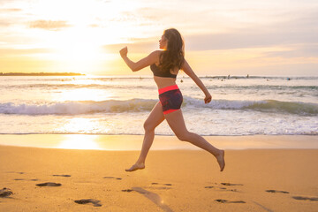 Fit woman running along a sandy beach