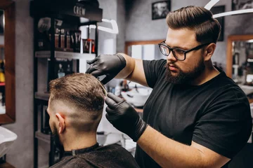 Fototapeten Client doing hair cut at a barber shop salon © Petro