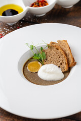 Crostini Fegatini on white porcelain plate on wooden table