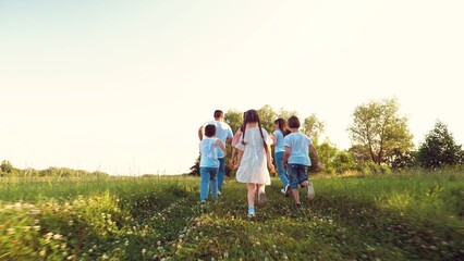 Cute little girl with family run fast in meadow grasses on summer vacation