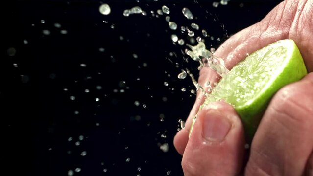 Squeezing lime juice with splashes. Filmed on a high-speed camera at 1000 fps. High quality FullHD footage
