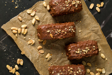 Chocolate sticks with peanuts on a dark background