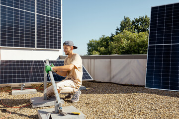 Man installs mounts for solar panels on a rooftop of household. Owner of property installing solar panels for self consumption