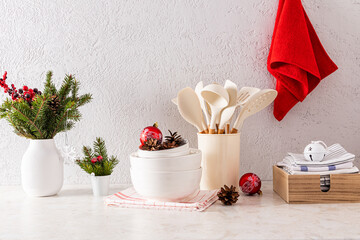 Winter decor on a Christmas kitchen countertop. spruce branches and red balls in a white vase and...