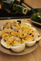 Close-up of cut mushrooms on a plate with curry seasoning and olive oil