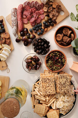 top view from above on the table with food, snacks, fresh herbs, olives, cheeses, sausages, cracker, lemonade, figs
