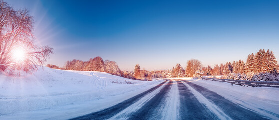 Beautiful winter road in natural sunny park.