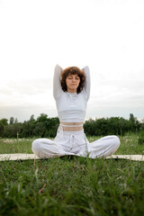 Concept of pranayama. Young sportive woman spend her free time on fresh air meditation. Girl closed...